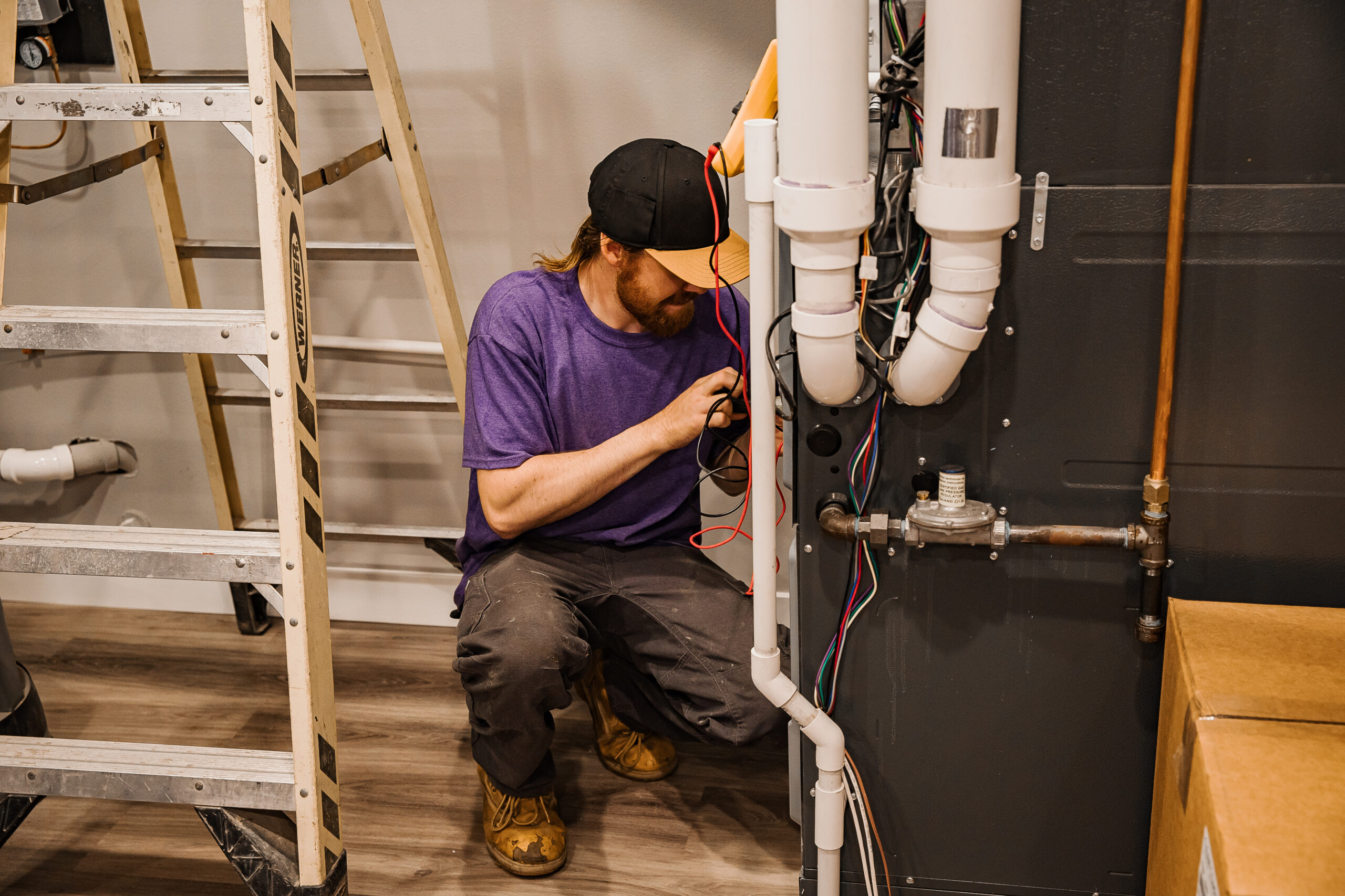 An Opie's Gold Heat n' Air repair technician services  a water heater in a St. Could, MN residence.